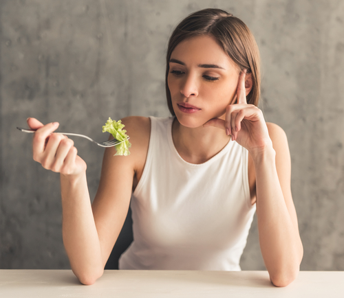 Eating,Disorder.,Girl,Is,Holding,A,Fork,With,Lettuce,And